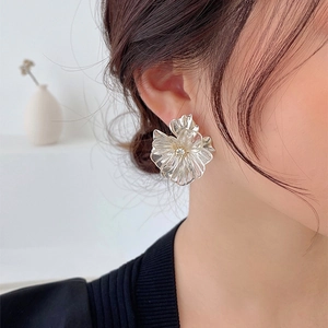 Clear floral resin earrings with golden center accents worn by a female model