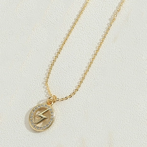 Macro detail of gold lightning bolt pendant with sparkling white zircon inlay necklace
