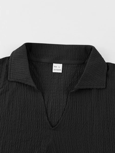 Detail of black seersucker short sleeve neckline showing 100% polyester fabric and L size tag