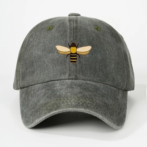 Close-up of embroidered bee pattern on washed dark grey cotton baseball cap with vent holes