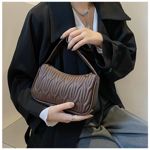 Close-up of brown PU leather shoulder bag with unique wavy pleated texture detail
