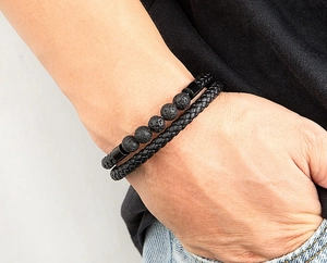 Detail of men's double-layer black leather braided bracelet and volcanic stone bead set
