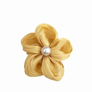Handmade yellow fabric flower hair accessory with central white faux pearl detail