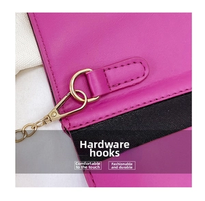 Detail of premium gold metal hooks and stitching on fuchsia and black leather bag