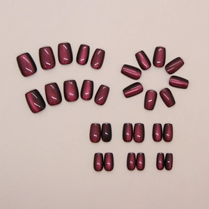Detail view of burgundy cat-eye press-on nails with shimmering magnetic effect and short square shape