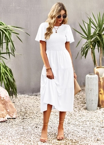 Detailed view of white maxi dress featuring elastic smocked bodice and ruffle sleeves