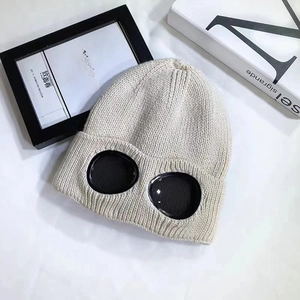 Close-up of beige knit beanie with built-in protective goggles for outdoor winter wear