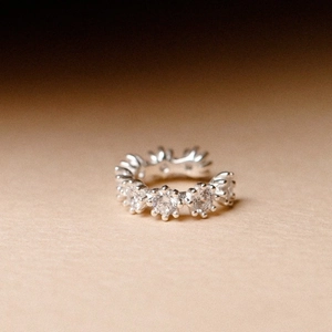 Vintage Artemis silver ear cuff with sparkling zircons on a clean beige background