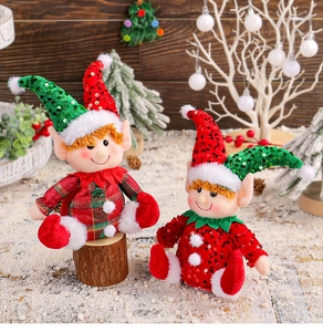 Detail of Christmas elf dolls with sequins and plaid hats sitting on rustic wood