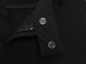 Close-up of black double-button waist closure and zipper detail on casual trousers