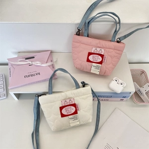 Détail de mini sacs matelassés rose et beige avec des sangles en denim bleu réglables