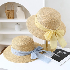 Elegant French straw hats with pearls, colorful ribbons and lace trim for beach outings