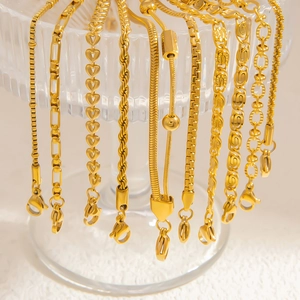 Assorted 18k gold plated stainless steel bracelets and necklaces on a glass rim