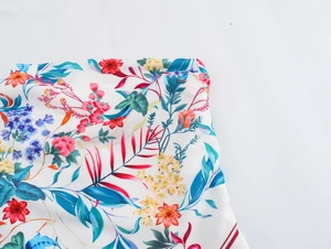 Close-up of lightweight chiffon fabric featuring vibrant tropical floral print on white