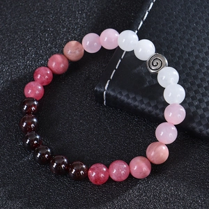 Détail macro du bracelet en perles de quartz fraise et grenat avec séparateur argenté