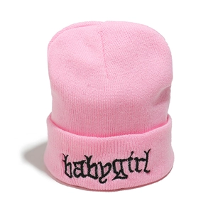 Dettaglio del berretto in maglia rosa con ricamo babygirl gotico nero sul risvolto