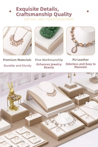 Detail view of champagne gold jewelry display stands with white PU leather textures