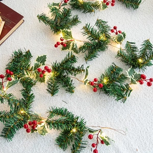 Christmas LED pine cone string light with red berries and warm glow on white faux fur carpet