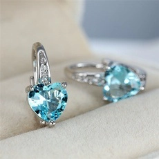 Macro detail of silver leverback earrings with blue heart crystals on velvet box