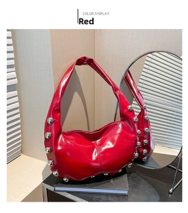 Detail view of red hobo bag with silver rivets on polished leather surface
