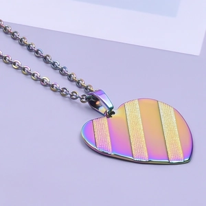 Macro shot of rainbow-plated heart pendant with vertical stripes on stainless steel chain