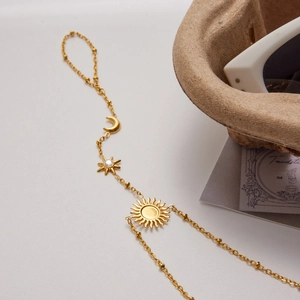 Detail of gold sun and moon slave bracelet with stars and clear zircon stones
