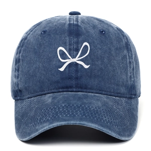 Close-up of white bow embroidery on navy washed cotton vintage baseball cap