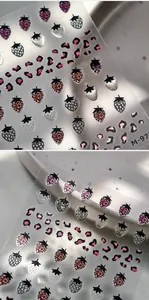 Macro detail of 3D embossed strawberry and leopard print nail art stickers with M-975 motifs