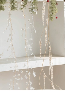 Close-up of acrylic snowflake beads and crystal ornaments hanging on a Christmas tree