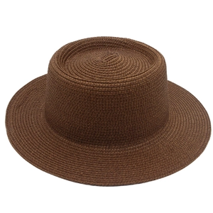 Detail view of woven straw texture on dark brown flat top French style sun hat