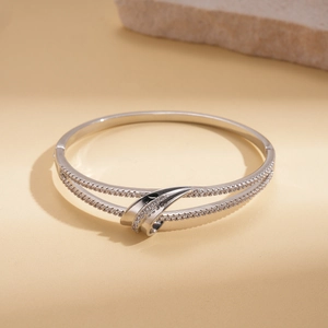 Detail of silver double-layered bangle featuring shimmering cubic zirconia in a cross design
