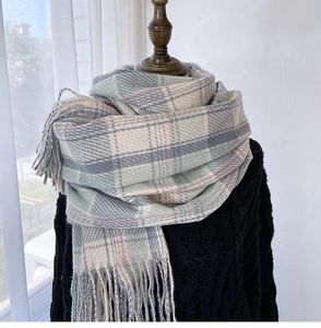 Close-up of soft plaid scarf with fringe tassels on mannequin in cozy winter setting