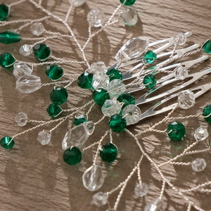 Macro detail of handmade bridal hair comb with green crystals and silver metal leaves
