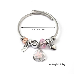 Detail view of silver beaded charm bracelet with pink crystals and heart pendant, 5.5cm diameter