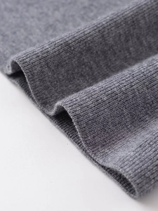 Détail du tissu en maille grise avec texture côtelée sur un pantalon large et doux