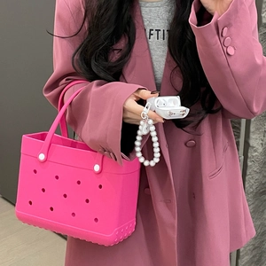 Close-up of pink EVA beach tote bag featuring white earbud case and pearl strap