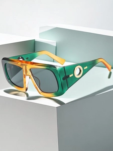 Detail of square gradient frame sunglasses with gold metal logo on a minimalist prop