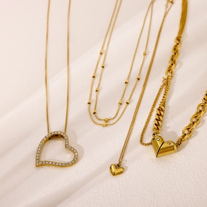 Detailed close-up of gold heart-shaped pendants with assorted chain textures and styles