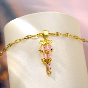 Elegant gold bow necklace with tiered pink rectangular crystals on a dainty chain