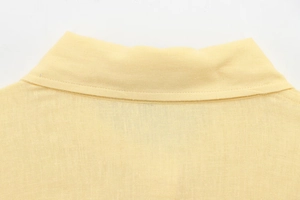 Close-up of yellow cotton linen shirt collar featuring precise stitching details