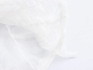 Detailed macro view of white lightweight fabric texture and fine stitching on the shirt edge