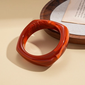 Detailed view of caramel resin geometric bracelet showing wood grain marble texture