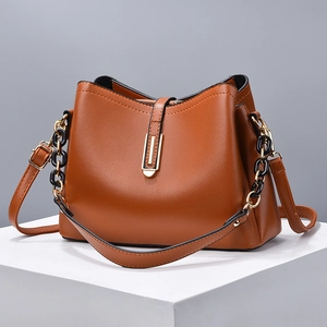 Brown leather trapezoid shoulder bag with gold hardware buckle and black chain strap