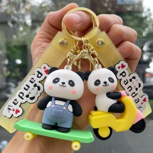 Close-up of cute panda keychains with blue overalls on skateboard and yellow motorcycle