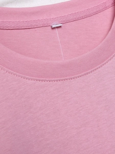 Nahaufnahme von rosa Baumwoll-T-Shirt mit Rippstrick-Rundhalsausschnitt und feiner Textur