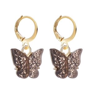 Detailed shot of golden butterfly earrings with dark brown glitter acrylic charms