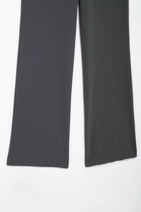 Detailed view of dark grey wide-leg trousers showing soft fabric texture and clean hemline
