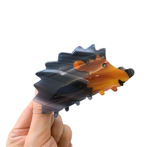 Unique hedgehog acetate hair claw clip with orange and black tortoiseshell texture