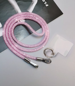 Pink rhinestone phone lanyard with transparent patch and metal buckle on grey background