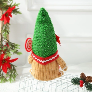 Christmas gnome doll with green knit hat and gingerbread color scheme on a white grid